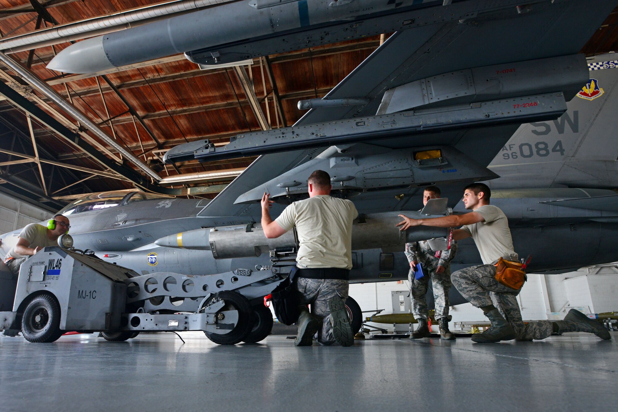 U.S. Air Force Airmen assigned to the 20th Aircraft Maintenance Squadron, 79th Aircraft Maintenance Unit, load munitions onto an F-16CM Fighting Falcon during a weapons load crew of the quarter competition at Shaw Air Force Base, S.C., July 31, 2015. The 79th AMU competed against the 77th AMU to determine who could accurately load three munitions the fastest. (U.S. Air Force photo by Senior Airman Jensen Stidham/Released)