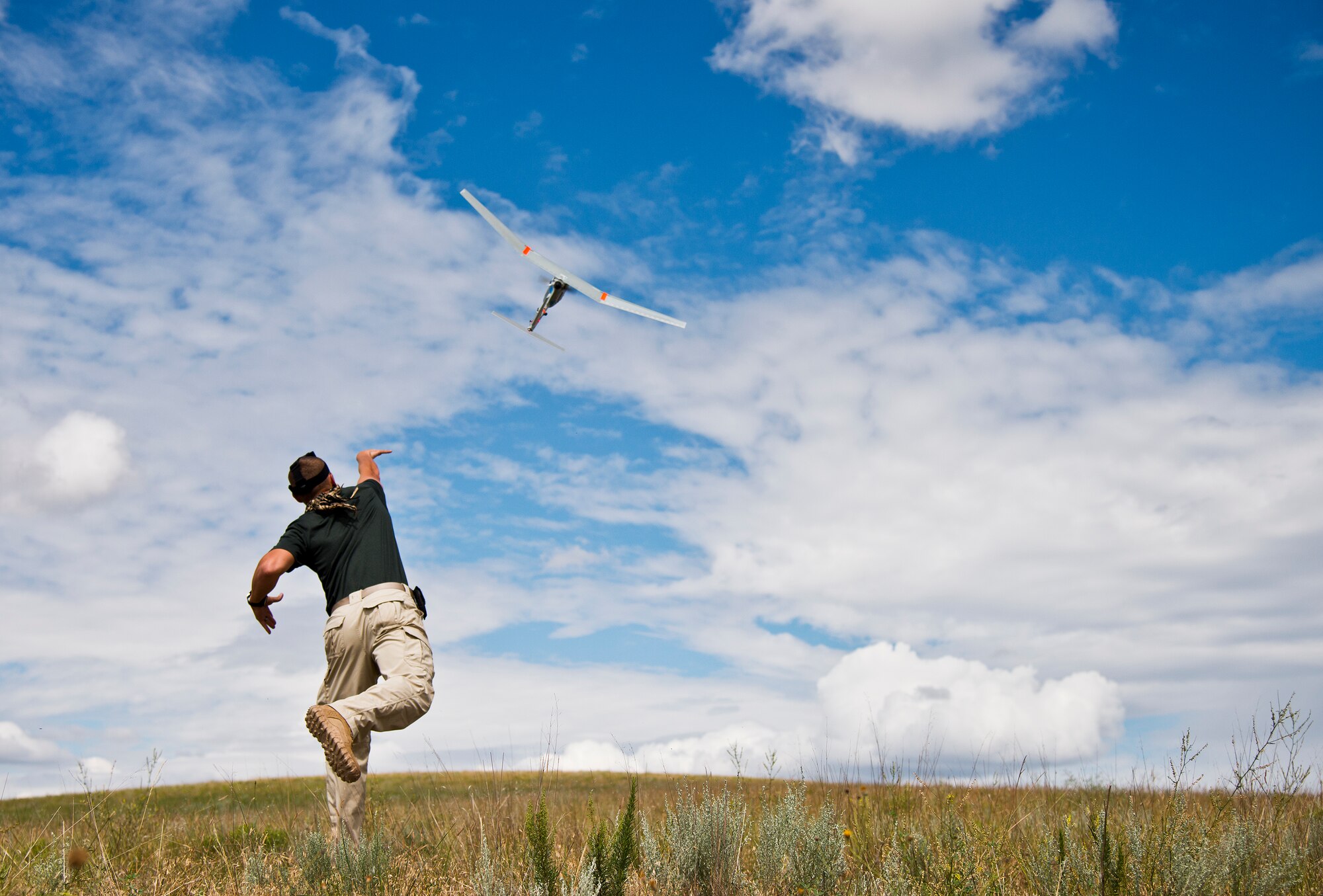 Staff Sgt. Leland Hastings, 919th Special Operations Security Forces Squadron, launches Raven-B, a four-by-four foot unmanned aerial system, into the skies above Camp Guernsey, Wyo., Aug. 4.  The 919th SOSFS brought the UAS to demonstrate its capabilities to other security forces units involved in a large field training exercise at the camp. The Raven-B has the ability to take photos, video in day or night, and even designate locations via an IR laser.  It also provides coordinates, magnetic azimuths, and linear distances creating a birds-eye view to topographical map. (U.S. Air Force photo/Tech. Sgt. Sam King)