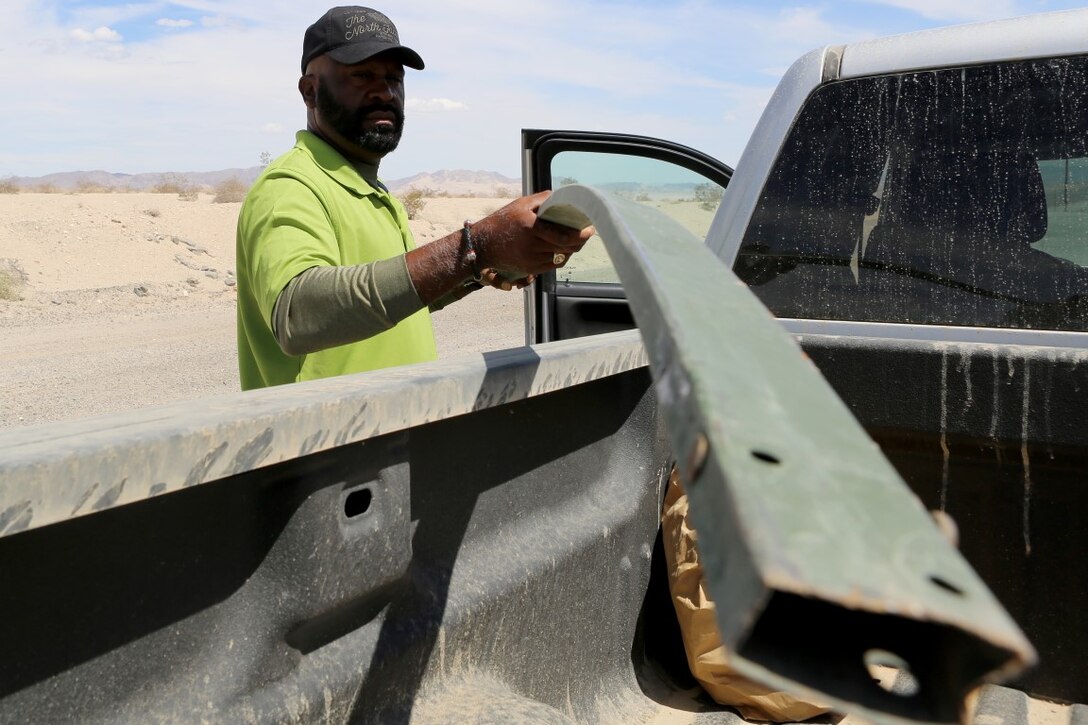 Jerome Joseph, the tactical safety officer for 1st Battalion, 3rd Marine Regiment, picks up debris off the side of the road to ensure Marines stay safe while conducting training aboard Marine Corps Air Ground Combat Center Twentynine Palms, Calif., Aug. 1. As the tactical safety officer, Joseph works tirelessly to ensure the Marines are mindful of safety at all times.