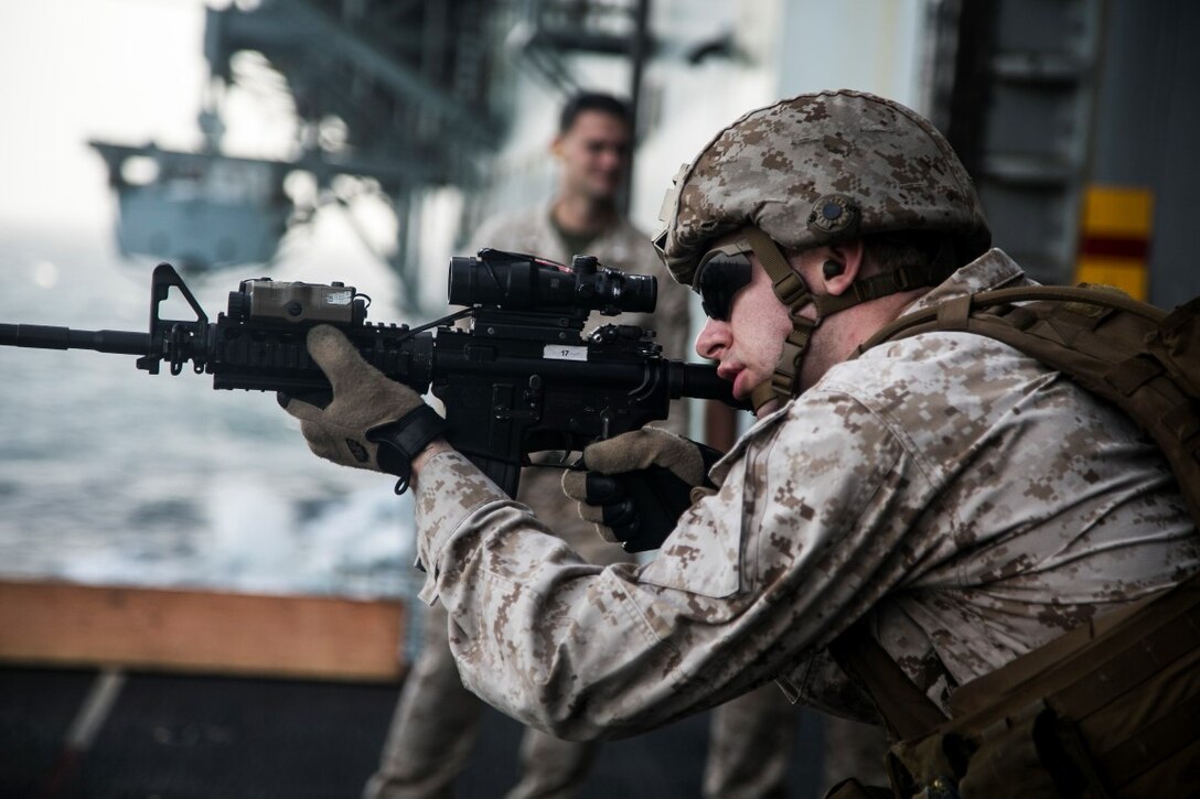 INDIAN OCEAN (July 31, 2015) A U.S. Marine with Lima Company, Battalion Landing Team 3rd Battalion, 1st Marine Regiment, 15th Marine Expeditionary Unit, moves toward his target during a deck shoot aboard the amphibious assault ship USS Essex (LHD 2). The Marines simulated moving through a hallway toward their threat as two-man teams to practice their in-house tactics. The 15th MEU is embarked on the Essex Amphibious Ready Group and deployed to maintain regional security in the U.S. 5th Fleet area of operations. (U.S. Marine Corps photo by Cpl. Anna Albrecht/Released)