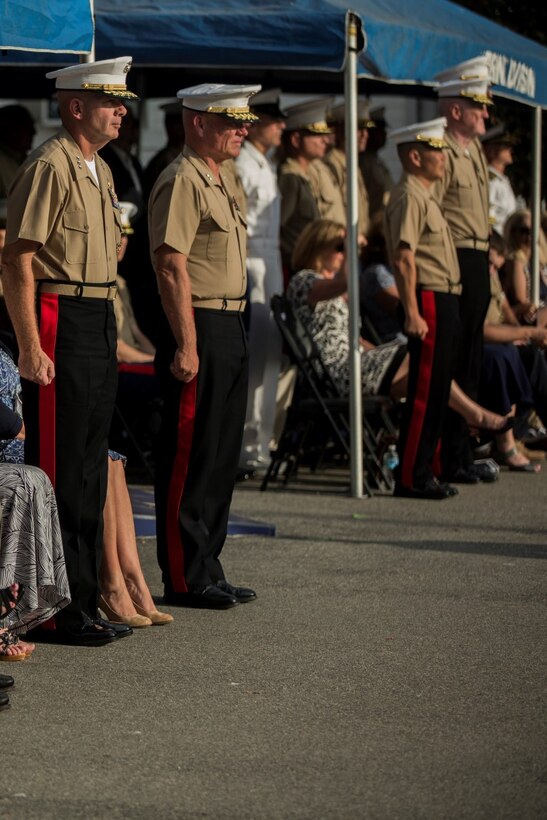 U.S. Marines and their guests stand for the playing of "Waltzing Matilda", the 1st Marine Division song, during a change of command ceremony at Marine Corps Base Camp Pendleton, Calif., July 30, 2015. The ceremony signifies the transfer of responsibility and authority of 1st Marine Division between Commanding Generals. (U.S. Marine Corps photo by Lance Cpl. Ryan Kierkegaard/Released)
