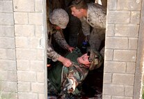 A U.S. Navy corpsman, assigned to the 1st Marine Division, conducts tactical combat casualty care training during the Combat Trauma Management Course, while being mentored by an instructor  from the 1st Mar. Div. Navy Education and Training Office, at the Strategic Operations facility, San Diego, July 30, 2015.The course, held once a month for 40 students, combines simulated injuries on role players and chaotic battlefield environments to prepare corpsmen and Marine combat life savers for the stress of saving lives in a real world operations. (U.S. Marine Corps photo by Staff Sgt. Bobbie A. Curtis)