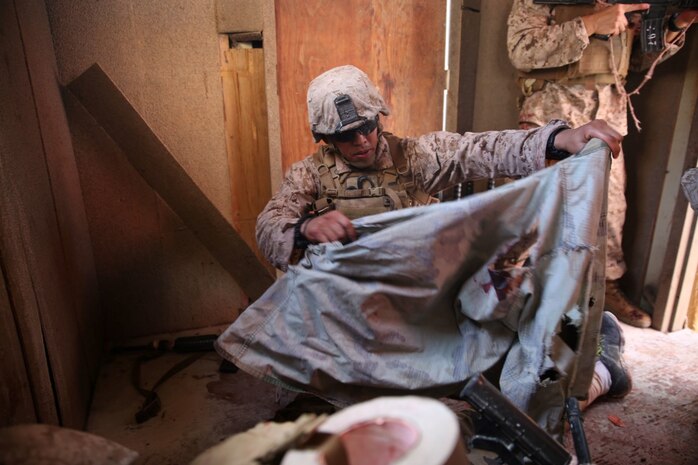 A U.S. Navy corpsman, assigned to the 1st Marine Division, conducts tactical combat casualty care training during the Combat Trauma Management Course, while being mentored by an instructor  from the 1st Mar. Div. Navy Education and Training Office, at the Strategic Operations facility, San Diego, July 30, 2015.The course, held once a month for 40 students, combines simulated injuries on role players and chaotic battlefield environments to prepare corpsmen and Marine combat life savers for the stress of saving lives in a real world operations.   (U.S. Marine Corps photo by Staff Sgt. Bobbie A. Curtis)