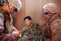 U.S. Navy corpsmen and Marines, assigned to various units in the 1st Marine Division, conduct tactical combat casualty care training during the Combat Trauma Management Course, taught by instructors with the 1st Mar. Div. Navy Education and Training Office, at the Strategic Operations facility, San Diego, July 30, 2015. The course, held once a month for 40 students, combines simulated injuries on role players and chaotic battlefield environments to prepare corpsmen and Marine combat life savers for the stress of saving lives in real world operations.   (U.S. Marine Corps photo by Staff Sgt. Bobbie A. Curtis)