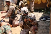 U.S. Navy corpsmen and Marines, assigned to various units in the 1st Marine Division, conduct tactical combat casualty care training during the Combat Trauma Management Course, taught by instructors with the 1st Mar. Div. Navy Education and Training Office, at the Strategic Operations facility, San Diego, July 30, 2015. The course, held once a month for 40 students, combines simulated injuries on role players and chaotic battlefield environments to prepare corpsmen and Marine combat life savers for the stress of saving lives in real world operations.   (U.S. Marine Corps photo by Staff Sgt. Bobbie A. Curtis)