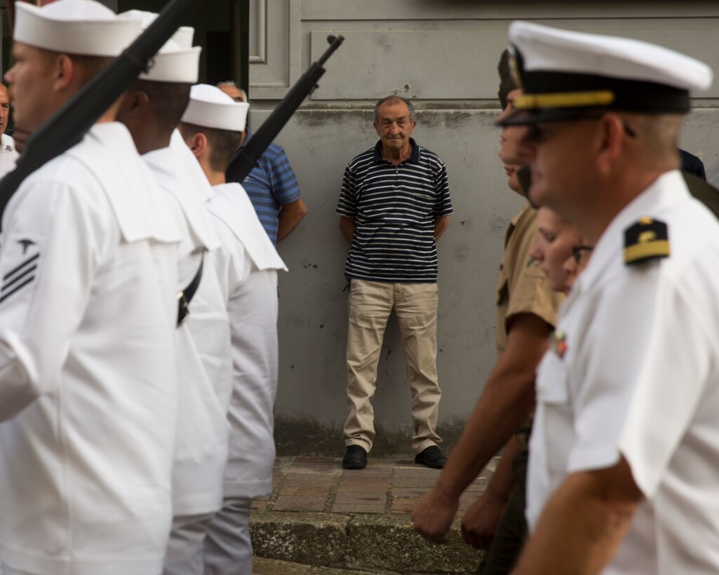 A man watches Marines and sailors with Special-Purpose Marine Air-Ground Task Force Crisis Response-Africa, Detachment A, parade through the streets of Troina, Sicily, Italy, August 2, 2015. The parade was part of a commemoration of the Battle of Troina  fought by Americans against the Nazis during World War II. (U.S. Marine Corps photo by Cpl. Olivia McDonald/Released)