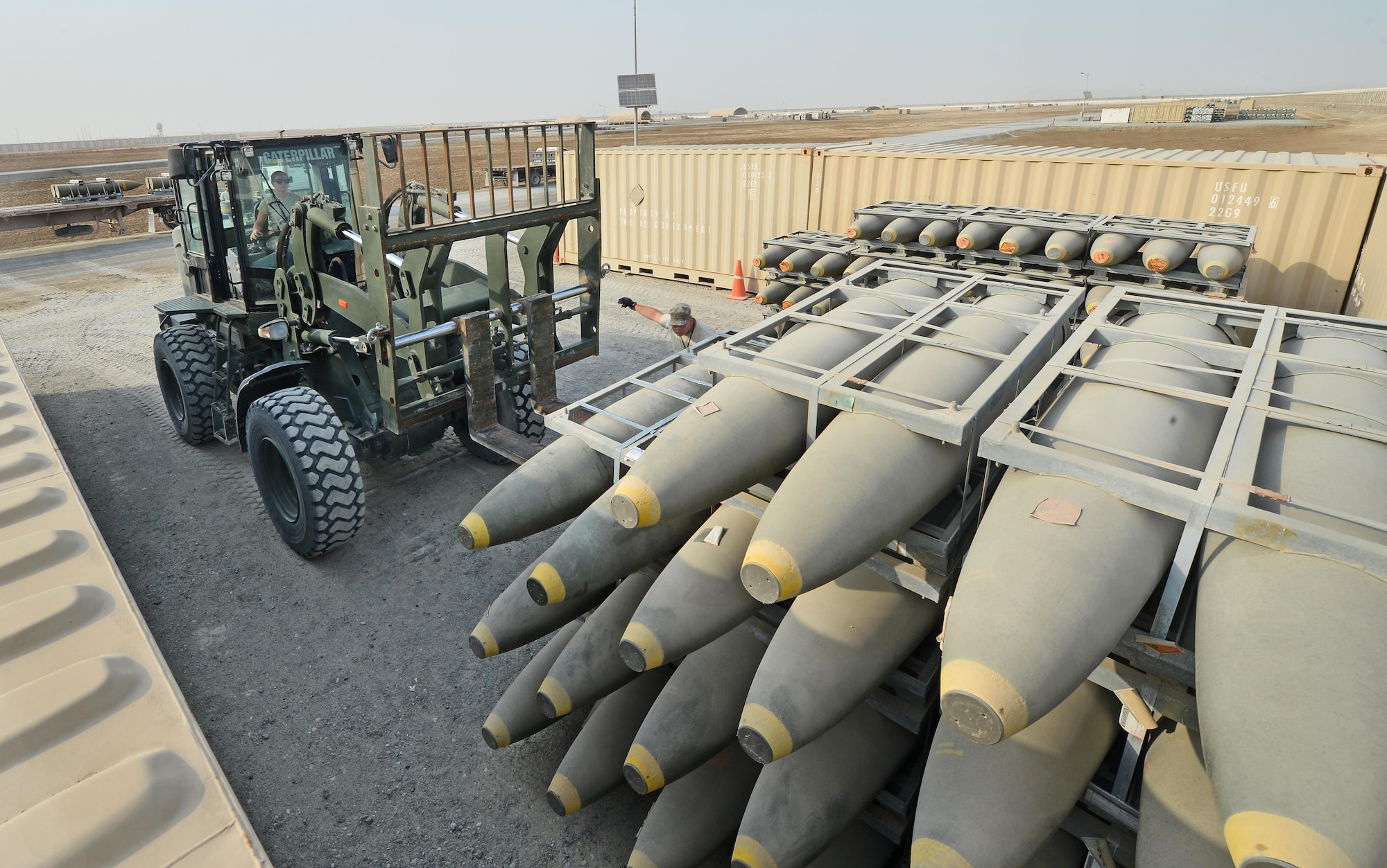 Airman First Class Karli Rinehart, Expeditionary Maintenance Squadron munitions storage crewmember, offloads munitions from a transport truck into a storage area at an undisclosed location in Southwest Asia July 30, 2015. Upon arrival, munitions are stockpiled in these designated areas until they are ready to be transported for final assembly. (U.S. Air Force photo/Tech. Sgt. Jeff Andrejcik)