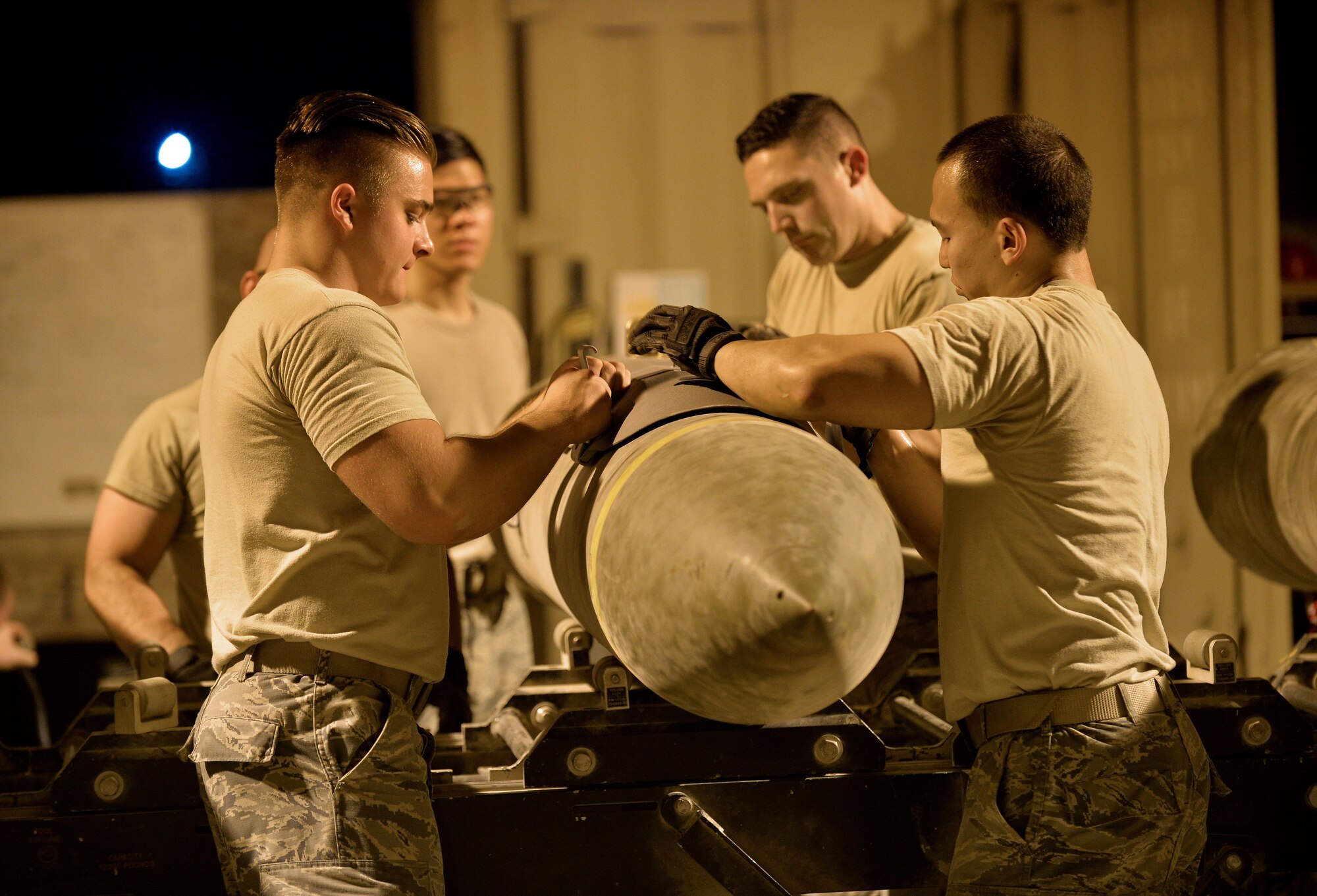 Expeditionary Maintenance Squadron conventional maintenance crewmembers assemble a Guided Bomb Unit 31 version 3 at an undisclosed location in Southwest Asia July 30, 2015. Munitions built here have been used in support of OPERATIONS INHERENT RESOLVE and FREEDOM SENTINEL, multi-national efforts to eliminate the Islamic State in Iraq and the Levant, or ISIL. (U.S. Air Force photo/Tech. Sgt. Jeff Andrejcik)