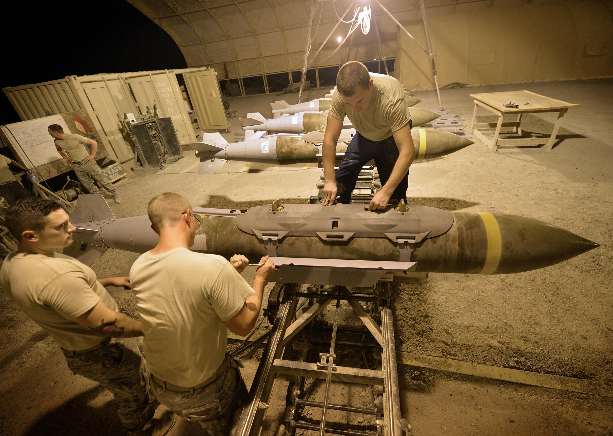 From left to right, Senior Airman Robert, Airman First Class Skylar and Senior Airman Jeremiah, Expeditionary Maintenance Squadron conventional maintenance crewmembers, put the finishing touches on a Guided Bomb Unit 31 version 3 at an undisclosed location in Southwest Asia July 30, 2015. Once the bombs are finished being built they are held in a designated area until an Air Tasking Order is received. The GBU-31 is a hardened target penetrator bomb manufactured here to meet the objectives of OPERATION INHERENT RESOLVE and FREEDOM SENTINEL, multi-national efforts to eliminate the Islamic State in Iraq and the Levant, or ISIL. (U.S. Air Force photo/Tech. Sgt. Jeff Andrejcik)