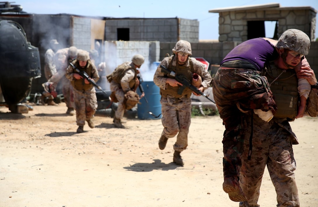 U.S. Navy corpsmen and Marines, assigned to various units in the 1st Marine Division, conduct tactical combat casualty care training during the Combat Trauma Management Course, taught by instructors with the 1st Mar. Div. Navy Education and Training Office, at the Strategic Operations facility, San Diego, July 30, 2015. The course, held once a month for 40 students, combines simulated injuries on role players and chaotic battlefield environments to prepare corpsmen and Marine combat life savers for the stress of saving lives in real world operations.   (U.S. Marine Corps photo by Staff Sgt. Bobbie A. Curtis)