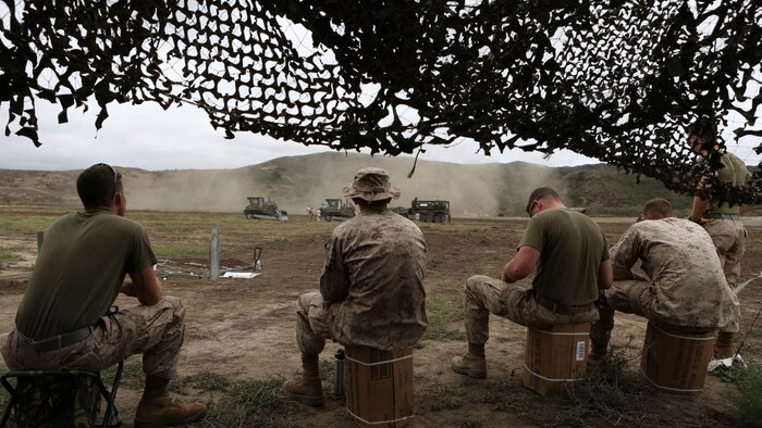 Marines from 4th Combat Engineer Battalion, 4th Marine Division, take a few seconds to rest as Ospreys practice landing for a casualty evacuation during a  battalion-level Fire Support Coordination Exercise aboard Marine Corps Base Camp Pendleton, Calif., July 14-24. The combat engineers' main role is to build, repair and maintain buildings, roads and power supplies. During the FSCEX, the Marines constructed trenches and tank traps.