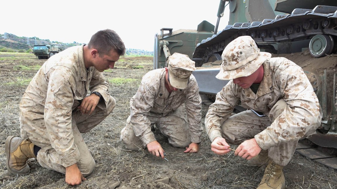 Marines from 4th Combat Engineer Battalion, 4th Marine Division, discuss location plans for their next task during a battalion-level Fire Support Coordination Exercise aboard Marine Corps Base Camp Pendleton, Calif., July 21. The combat engineers' main role is to build, repair and maintain buildings, roads and power supplies; during the FSCEX, the Marines constructed trenches and tank traps.