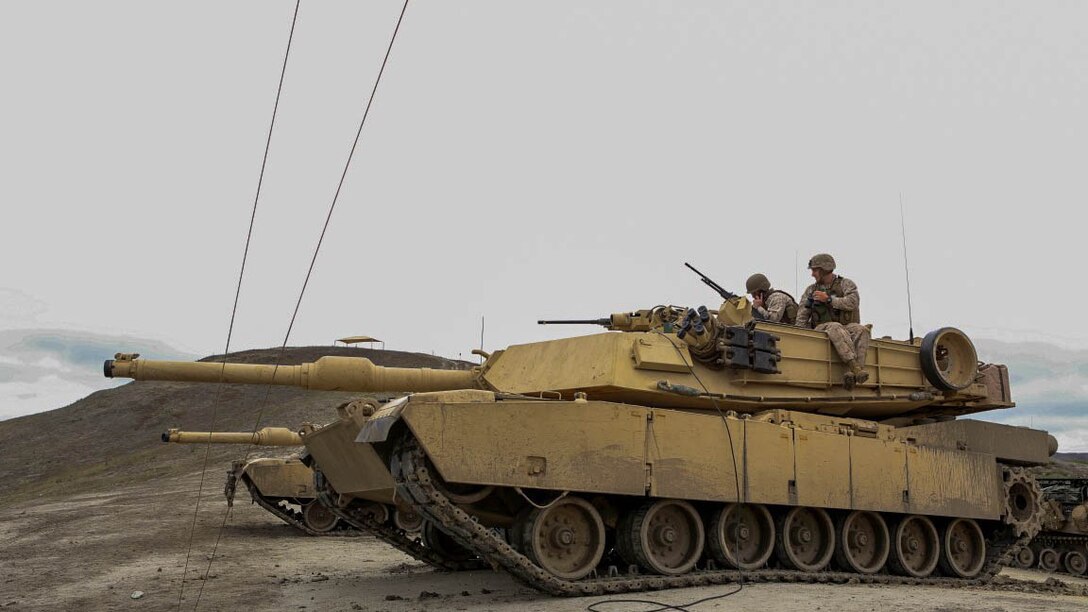 Captain Alexander R. Diener, a fire support coordinator with 4th Tank Battalion, 4th Marine Division, right, looks out onto the range as a Marine calls in to plot shots during a battalion-level Fire Support Coordination Exercise aboard Marine Corps Base Camp Pendleton, Calif., July 21. Training included live fire exercises, simulated medical evacuation operations and employing artillery assets to support operations.
