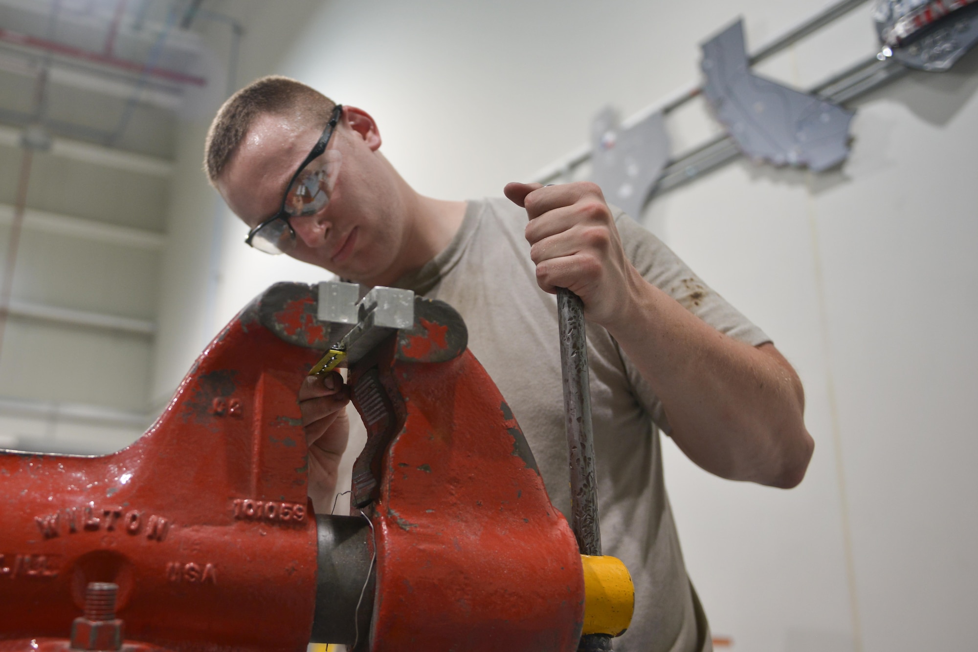 Senior Airman Adam Bentz, 379th Expeditionary Maintenance Squadron's fabrication flight, adjusts a KC-135 Stratotanker spoiler access panel part before returning to the flight line for application August 4, 2015 at Al Udeid Air Base, Qatar. The fabrications flight is partitioned into the aircraft structural maintenance and metal technology sections that make on-site repairs to aircraft deployed to Al Udeid. Most fabrications can be conducted on the flight line. For others, Airmen would bring in the part or create what is needed to keep the aircraft flying within hours. (U.S. Air Force photo/ Staff Sgt. Alexandre Montes)