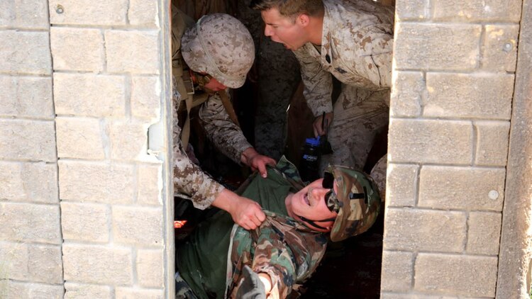A U.S. Navy corpsman, assigned to the 1st Marine Division, conducts tactical combat casualty care training during the Combat Trauma Management Course, while being mentored by an instructor  from the 1st Mar. Div. Navy Education and Training Office, at the Strategic Operations facility, San Diego, July 30, 2015.The course, held once a month for 40 students, combines simulated injuries on role players and chaotic battlefield environments to prepare corpsmen and Marine combat life savers for the stress of saving lives in a real world operations. 