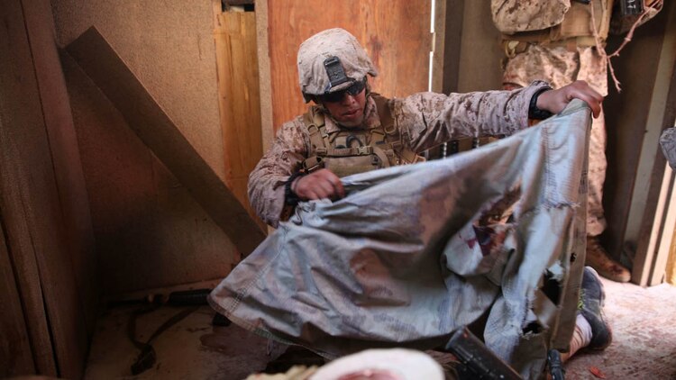 A U.S. Navy corpsman, assigned to the 1st Marine Division, conducts tactical combat casualty care training during the Combat Trauma Management Course, while being mentored by an instructor  from the 1st Mar. Div. Navy Education and Training Office, at the Strategic Operations facility, San Diego, July 30, 2015.The course, held once a month for 40 students, combines simulated injuries on role players and chaotic battlefield environments to prepare corpsmen and Marine combat life savers for the stress of saving lives in a real world operations.   