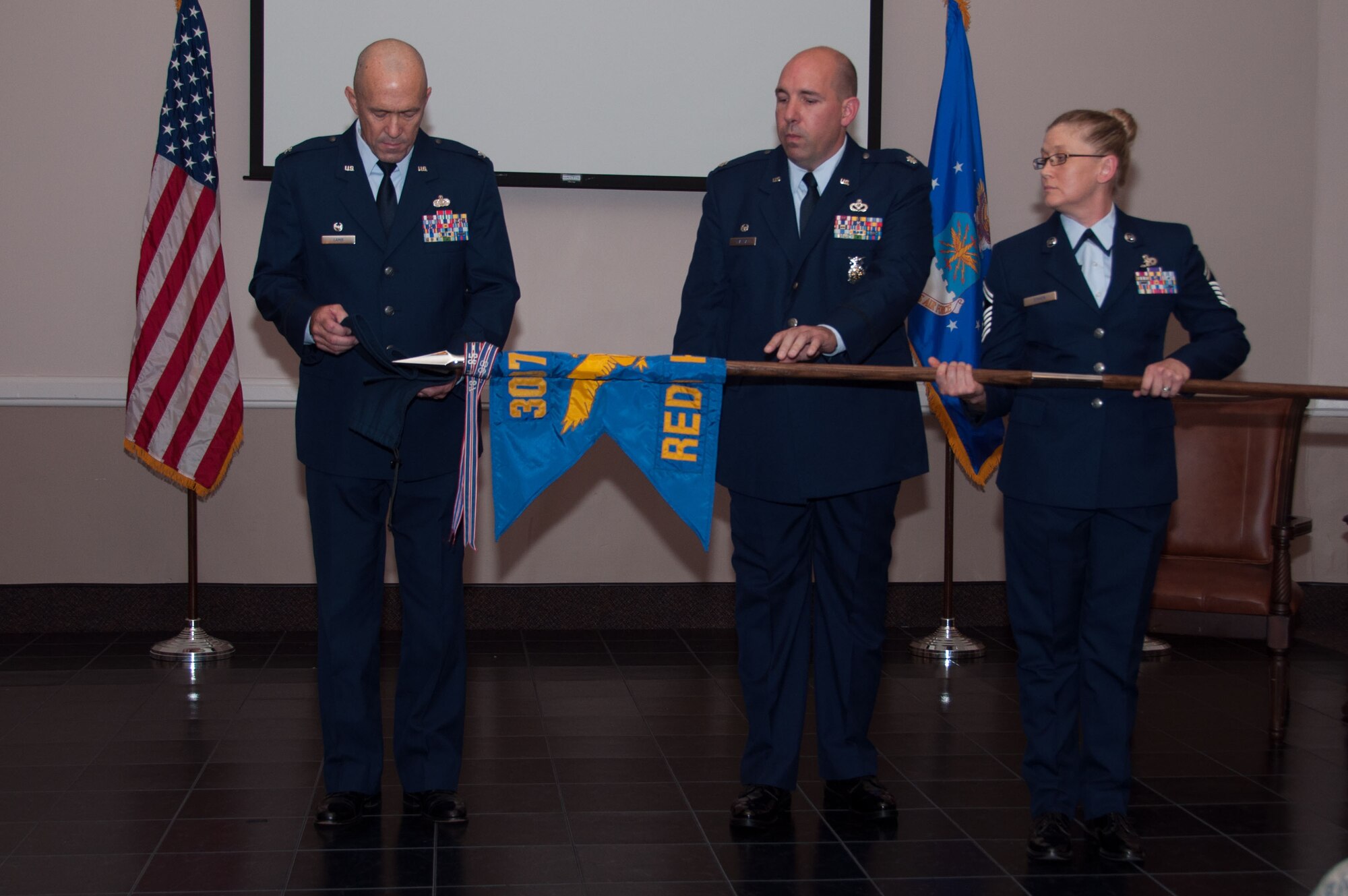 U. S. Air Force Colonel Timothy Lamb, commander of the 622th Civil Engineer Group, Dobbins Air Force Base, Georgia, and Lt. Col. Charles Chapman, 307th RED HORSE commander, furl and prepare to encase the unit’s flag at Barksdale Air Force Base, Louisiana., Aug. 2, 2015. During the inactivation ceremony, the furling and encasing of the organization’s flag, signifies the unit has completed its mission. The 307th RH was inactivated after 44 years of service making it the longest continuously operational RED HORSE squadron in the Air Force. (U.S. Air Force photo by Master Sgt. Laura Siebert)