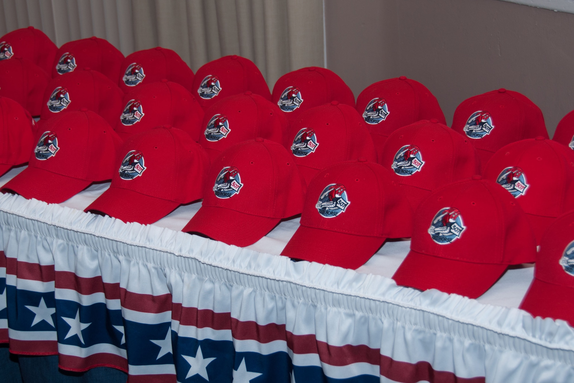 307th RED HORSE Hats were assembled on a table during the unit's  inactivation ceremony on Aug. 2, 2015 at Barksdale Air Force Base, Louisiana.  Each hat has a name embroidered on it representing a member of the 307th RED HORSE Alumni who has passed over the last 44 years. Every year at family day the hats are assembled to remember those who can no longer physically gather.  After the ceremony each hat and a commemorative squadron coin were presented to the surviving family members. (U.S. Air Force photo by Master Sgt. Laura Siebert)