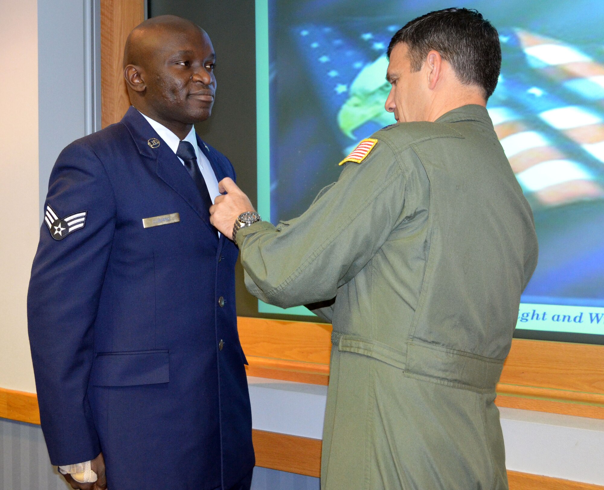 Colonel Al Lupenski, commander of the 439th Airlift Wing, Westover Air Reserve Base, Mass., pins an Air Force Achievement Medal on Senior Airman Maurice Ojwang. Ojwang was awarded this medal for his efforts in the finance office at F.E. Warren Air Force Base, Wyo.