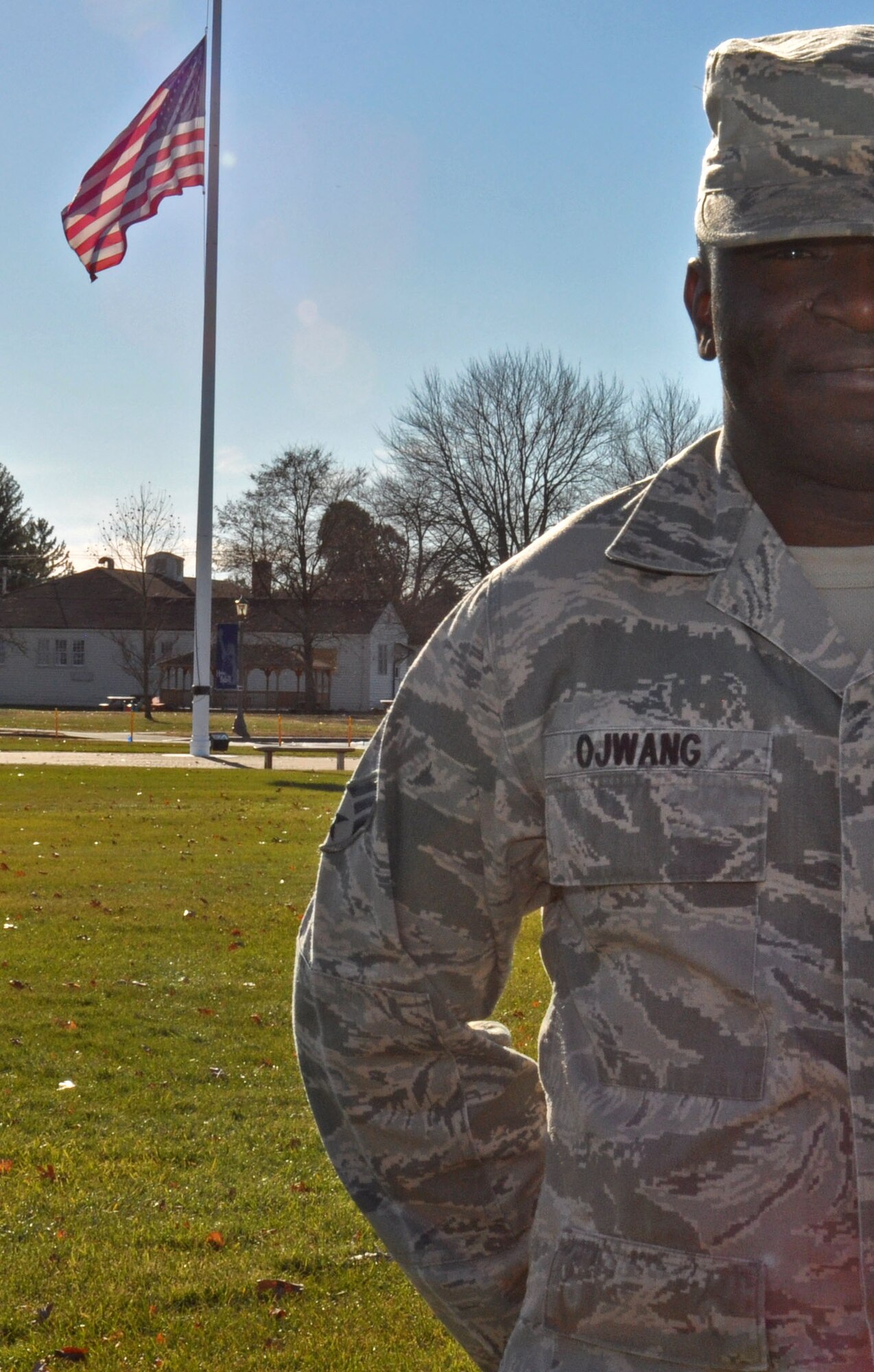 Senior Airman Maurice Ojwang, a financial services technician with the 439th Airlift Wing, proudly stands in front of the American Flag at Westover Air Reserve Base, Mass. Ojwang, originally from Kenya, obtained United States citizenship upon graduation from Air Force basic military training. (U.S. Air Force photo by SrA. Monica Ricci/Released)