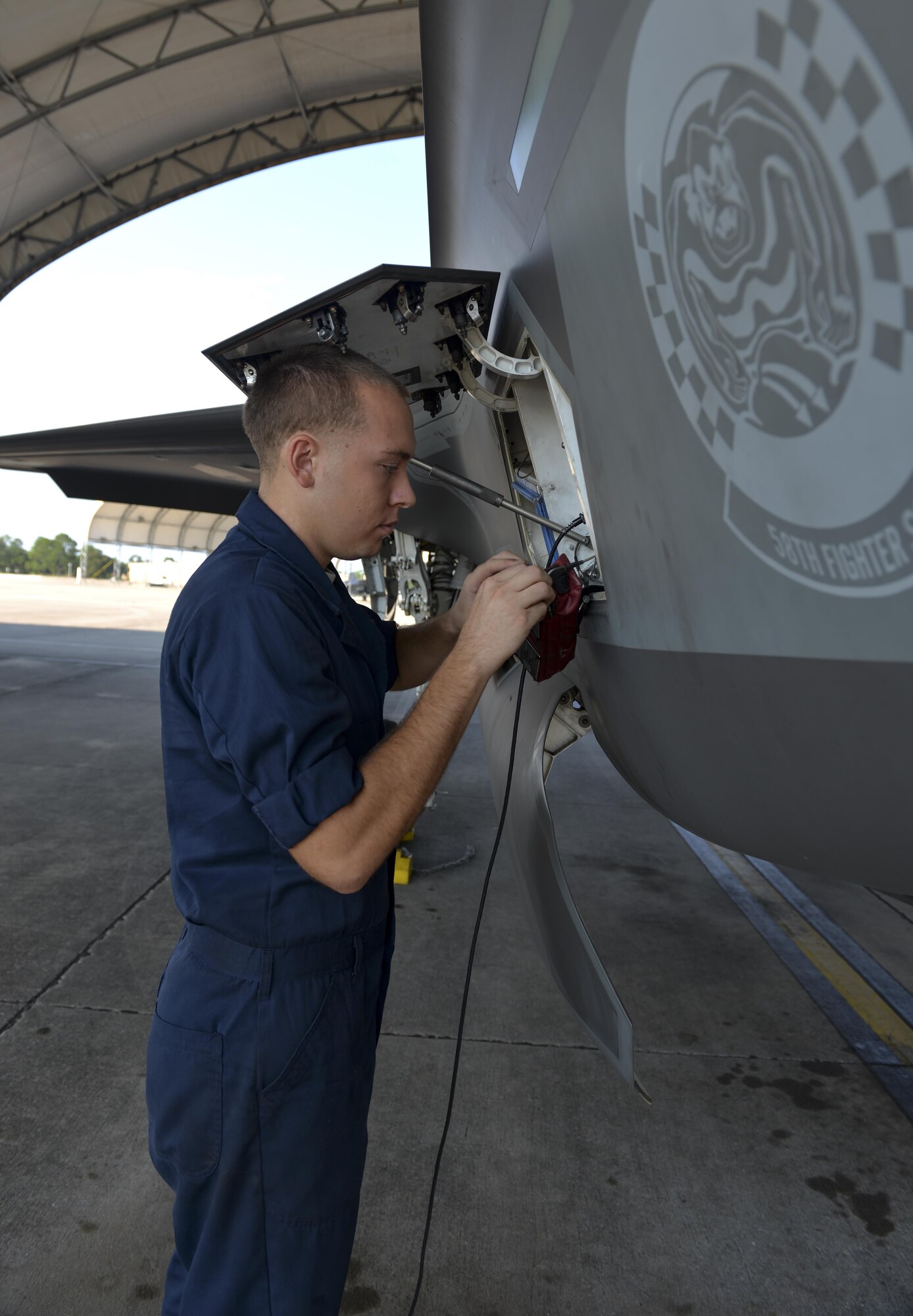 Airman 1st Class Zachary Weeks, 33rd Aircraft Maintenance Squadron crew chief, stores pins from an F-35A Lighting II before launch at Eglin Air Force Base, Fla., August 4, 2015. Week’s responsibility on the flight line is to safely inspect and launch the F-35A Lighting II. (U.S. Air Force Photo/Senior Airman Andrea Posey)