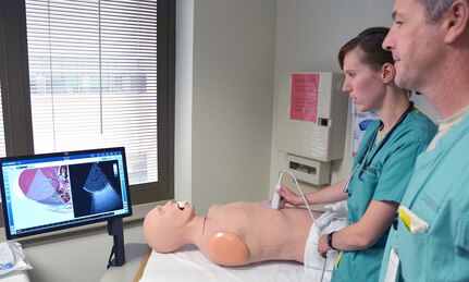 San Antonio Military Medical Center Department of Emergency Medicine Air Force Capt. (Dr.) Erin Hanlin and Dr. Jeremiah Johnson practice using an ultrasound 3-D simulator during the SIM Center open house July 22.