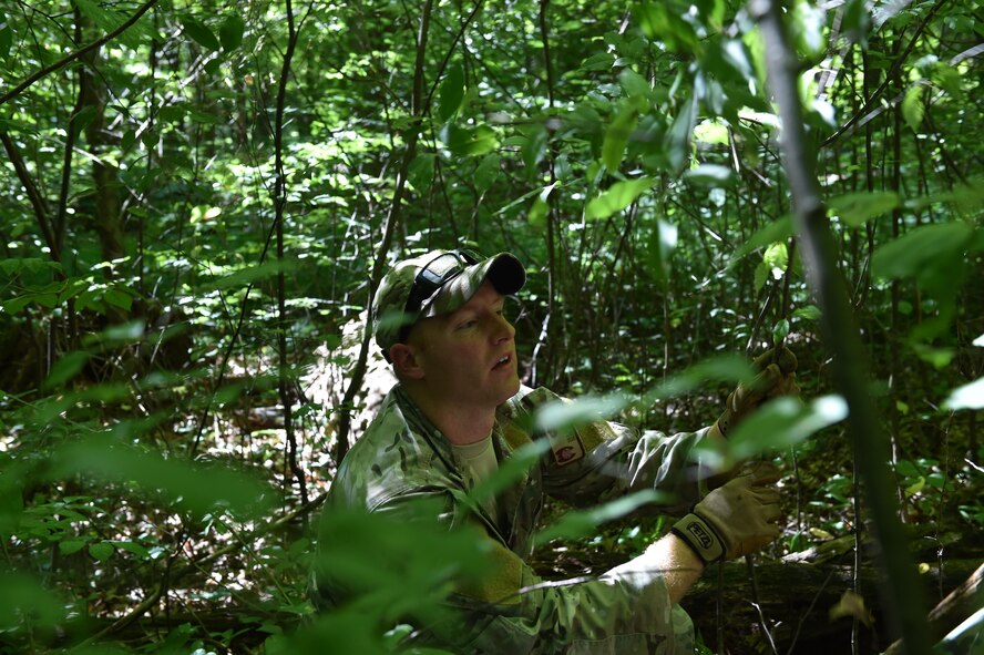 Staff Sgt. Zachariah Angel, Survival, Evasion, Resistance and Escape (SERE) operations craftsman with the 910th Operations Support Squadron, builds a demonstration survival shelter here, July 31, 2015. Angel led approximately ten aircrew members in a combat survival skills training course at Camp Ravenna Joint Military Training Center. The course is a triennial requirement for aircrew members and provides skills for surviving, evading capture, resisting the enemy and escaping a hostile environment. (U.S. Air Force photo/Eric M. White)