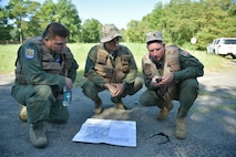 Capt. Teng Yang, Maj. Vince Repucci and Lt. Col. Perry Sorg (left to right), all aircrew members with the 757th Airlift Squadron, use GPS coordinates and a map to plot their route through the woods during a combat survival skills training course here, July 31, 2015. Approximately ten aircrew members were at Camp Ravenna Joint Military Training Center for an aircrew combat survival skills training course. The course is a triennial requirement for aircrew members and provides skills for surviving, evading capture, resisting the enemy and escaping a hostile environment. (U.S. Air Force photo/Eric M. White