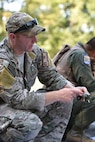 Staff Sgt. Zachariah Angel, Survival, Evasion, Resistance and Escape (SERE) operations craftsman with the 910th Operations Support Squadron, demonstrates compass features here, July 31, 2015. Angel led approximately ten aircrew members in a combat survival skills training course at Camp Ravenna Joint Military Training Center. The course is a triennial requirement for aircrew members and provides skills for surviving, evading capture, resisting the enemy and escaping a hostile environment. (U.S. Air Force photo/Eric M. White)  