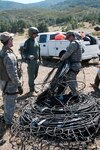 Two members of the California National Guard's Joint Task Force Domestic
Support-Counterdrug speak with a U.S. Forest Service agent (center) while
bundling irrigation line to be removed from Mendocino National Forest. The
25-agency effort Operation Full Court Press removed 40 miles of irrigation
line from California forests this summer in addition to 25 tons of other
garbage, 38 weapons, 20 vehicles, $30,000 in cash, 632,000 marijuana plants
and a ton of processed marijuana.