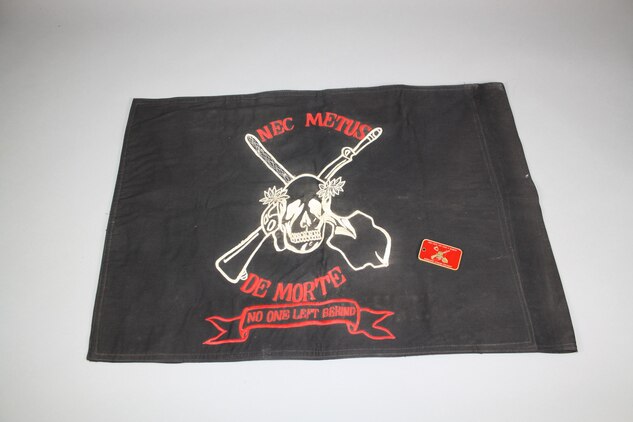 An unofficial flag or guidon with the matching challenge coin from mortuary affairs, 4th Force Service Support Group, 4th Marine Division, nominated for exhibit in the final phase of the museum, July 20, aboard Marine Corps Base Quantico.