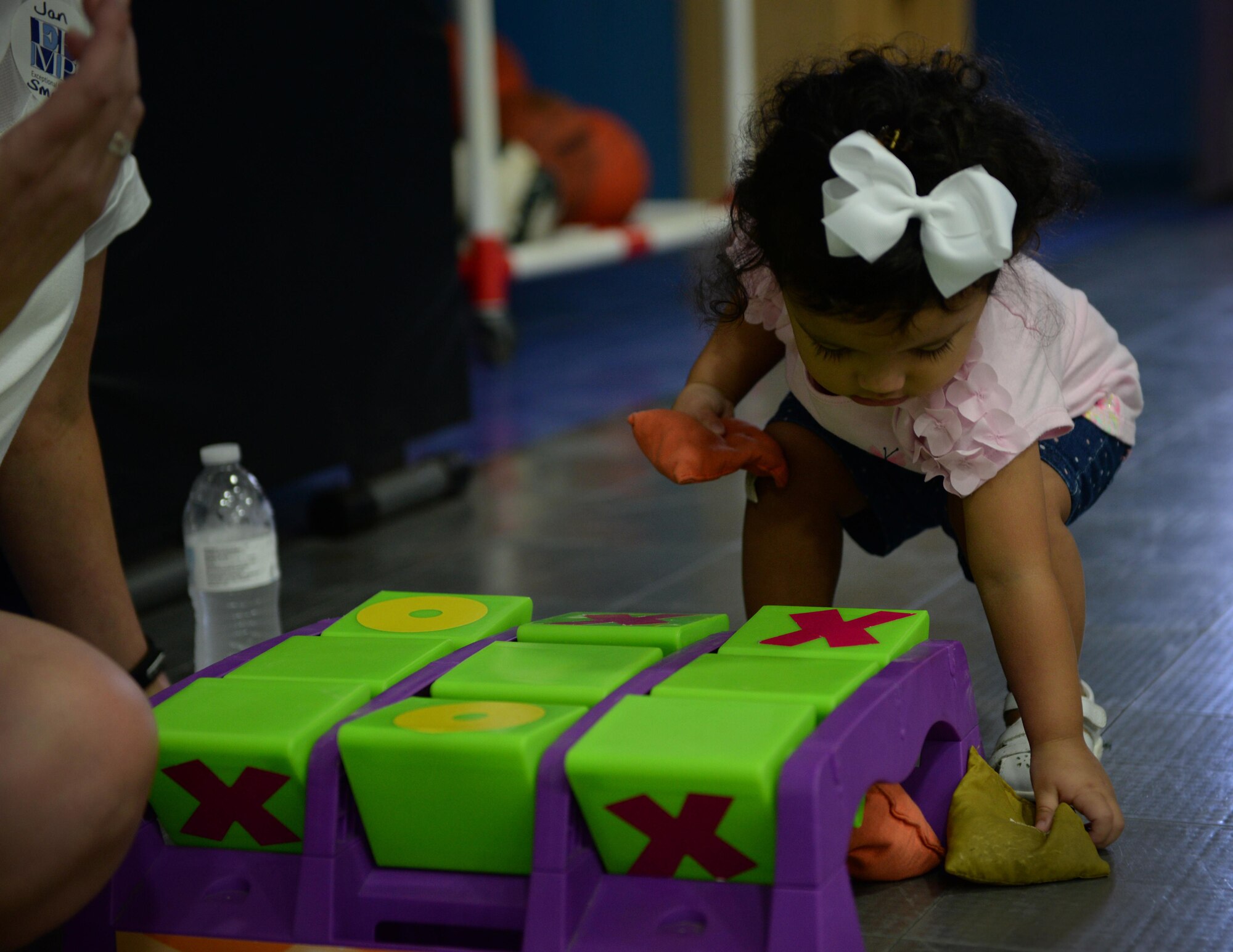 Ariana Rose Camacho, daughter of Capt. Santiago Camacho, 335th Training Squadron force support training flight commander, plays tic-tac-toe with bean bags at a play area during the Exceptional Family Member Program Information and Resource Fair, Aug. 1, 2015, Keesler Air Force Base, Miss. EFMP, with help from Keesler Integrated Resource Team organizations, provided carnival games, hands-on activities and information about support programs to families with special needs dependents. (U.S. Air Force photo by Senior Airman Holly Mansfield)