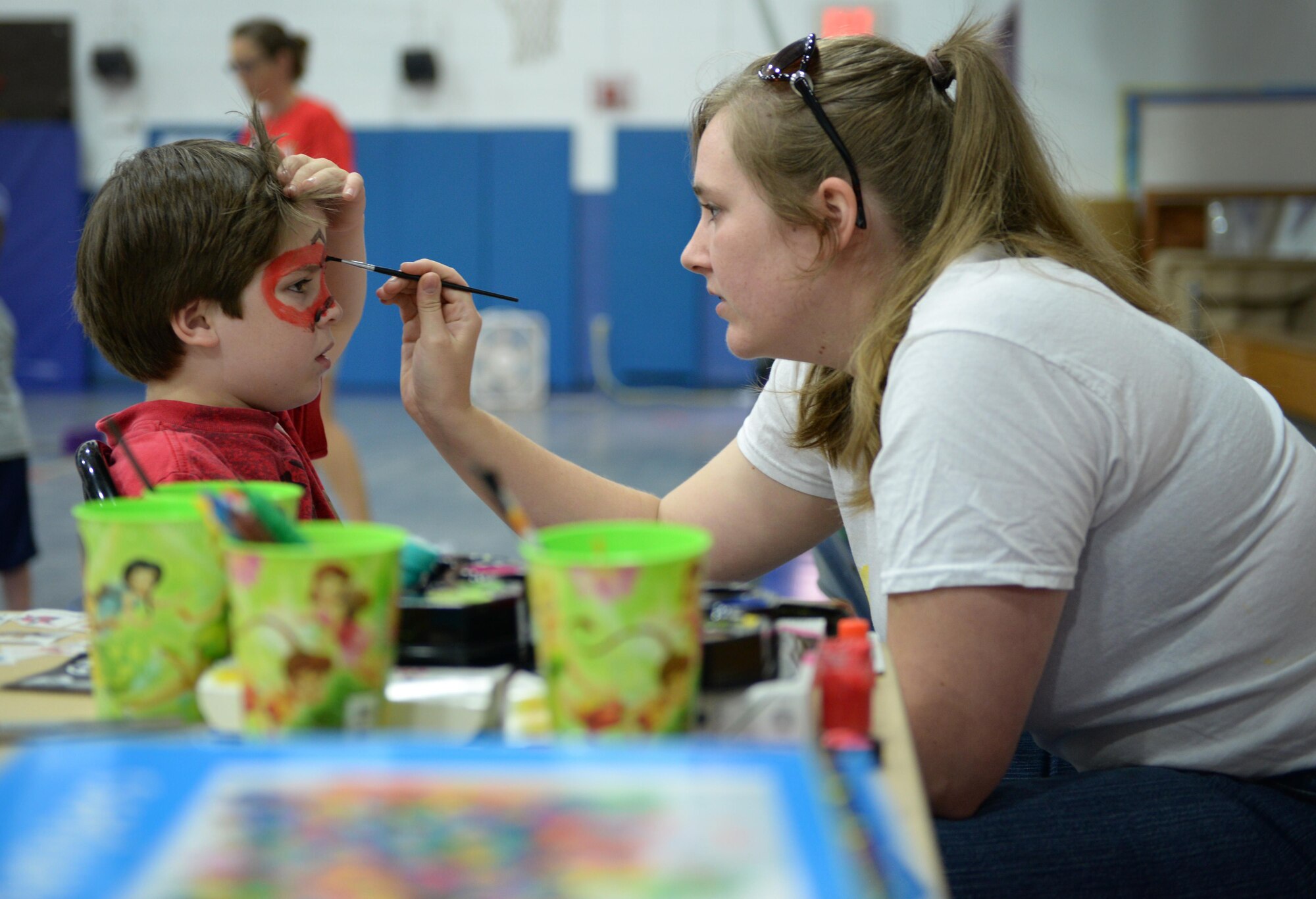 Ian Johns, son of Staff Sgt. Dennis Johns, 335th Training Squadron instructor, gets his face painted at a play area during the Exceptional Family Member Program Information and Resource Fair, Aug. 1, 2015, Keesler Air Force Base, Miss. EFMP, with help from Keesler Integrated Resource Team organizations, provided carnival games, hands-on activities and information about support programs to families with special needs dependents. (U.S. Air Force photo by Senior Airman Holly Mansfield)
