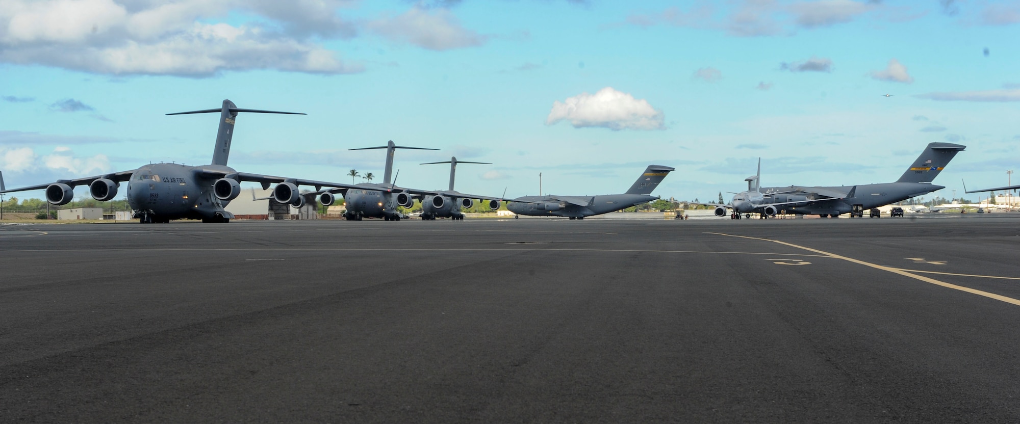 Five U.S. Air Force C-17 Globemasters III from the 535th Airlift Squadron taxi prior to take off on Joint Base Pearl Harbor-Hickam, Hawaii, July 31, 2015. The day featured the participation of 15th Wing C-17 Globemasters III and F-22 Raptors of the 199th fight squadron, as well as KC-10 Extenders from Travis Air Force Base, California, and tested the ability for the aircrafts and personnel to work together to complete a mission. (U.S. Air Force photo by Tech. Sgt. Terri Paden/Released)
