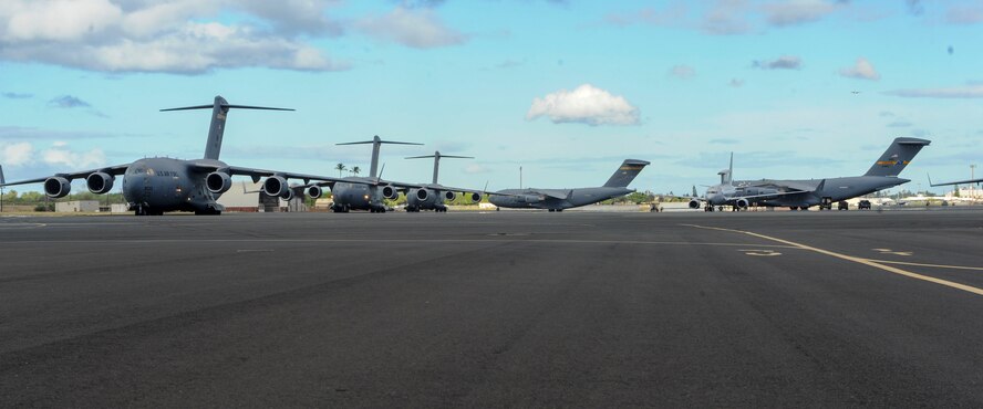 Five U.S. Air Force C-17 Globemasters III from the 535th Airlift Squadron taxi prior to take off on Joint Base Pearl Harbor-Hickam, Hawaii, July 31, 2015. The day featured the participation of 15th Wing C-17 Globemasters III and F-22 Raptors of the 199th fight squadron, as well as KC-10 Extenders from Travis Air Force Base, California, and tested the ability for the aircrafts and personnel to work together to complete a mission. (U.S. Air Force photo by Tech. Sgt. Terri Paden/Released)
