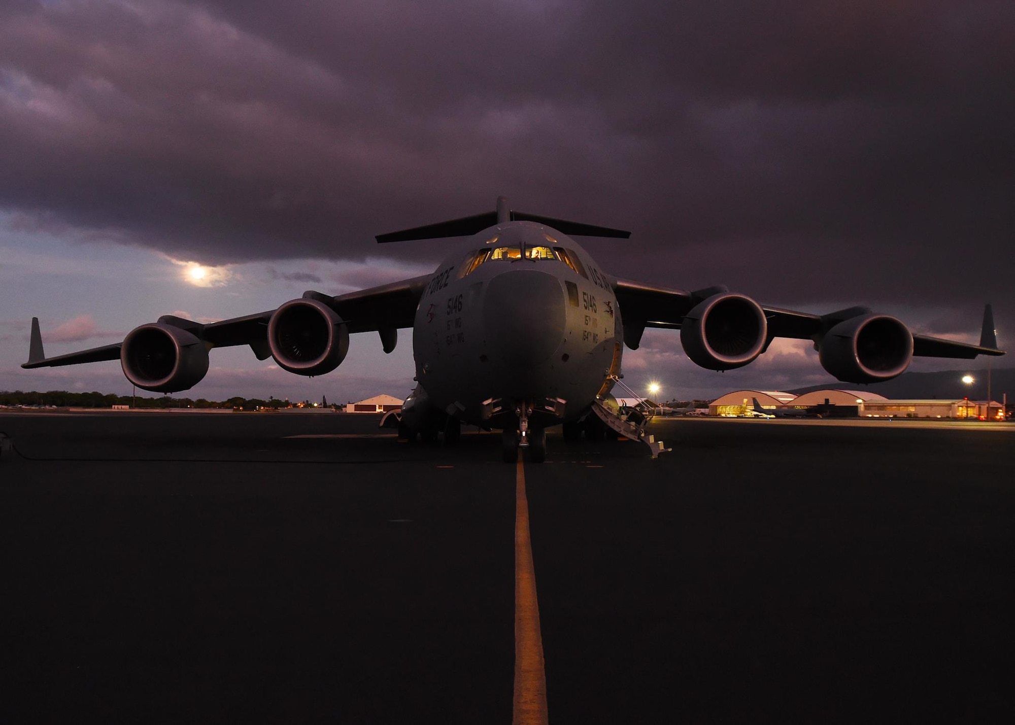 A U.S. Air Force C-17 Globemaster III from the 535th Airlift Squadron sits on the parking ramp as the aircrew run their preflight checks on Joint Base Pearl Harbor-Hickam, Hawaii, July 31, 2015. Active duty and Air National Guard Airmen joined forces in a Warrior Day to demonstrate the cooperation and capabilities of total force integration. The 15th and 154th aircraft maintenance squadrons generated the five C-17 aircraft and the four F-22 used during the training day. (U.S. Air Force photo by Tech. Sgt. Aaron Oelrich/Released)
