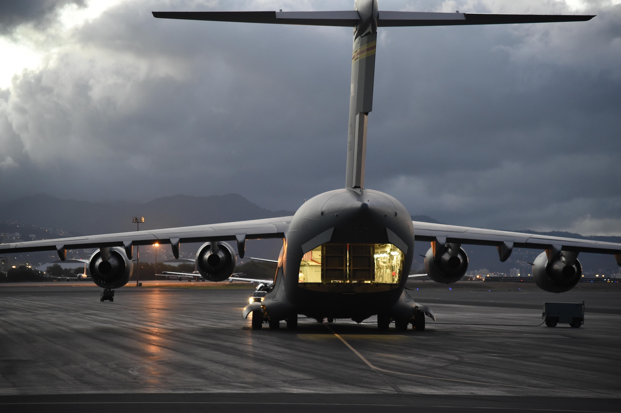 A U.S. Air Force C-17 Globemaster III from the 535th Airlift Squadron sits on the parking ramp as the aircrew run their preflight checks on Joint Base Pearl Harbor-Hickam, Hawaii, July 31, 2015. Active duty and Air National Guard Airmen joined forces in a Warrior Day to demonstrate the cooperation and capabilities of total force integration. The 15th and 154th aircraft maintenance squadrons generated the five C-17 aircraft and the four F-22 used during the training day. (U.S. Air Force photo by Tech. Sgt. Aaron Oelrich/Released)
