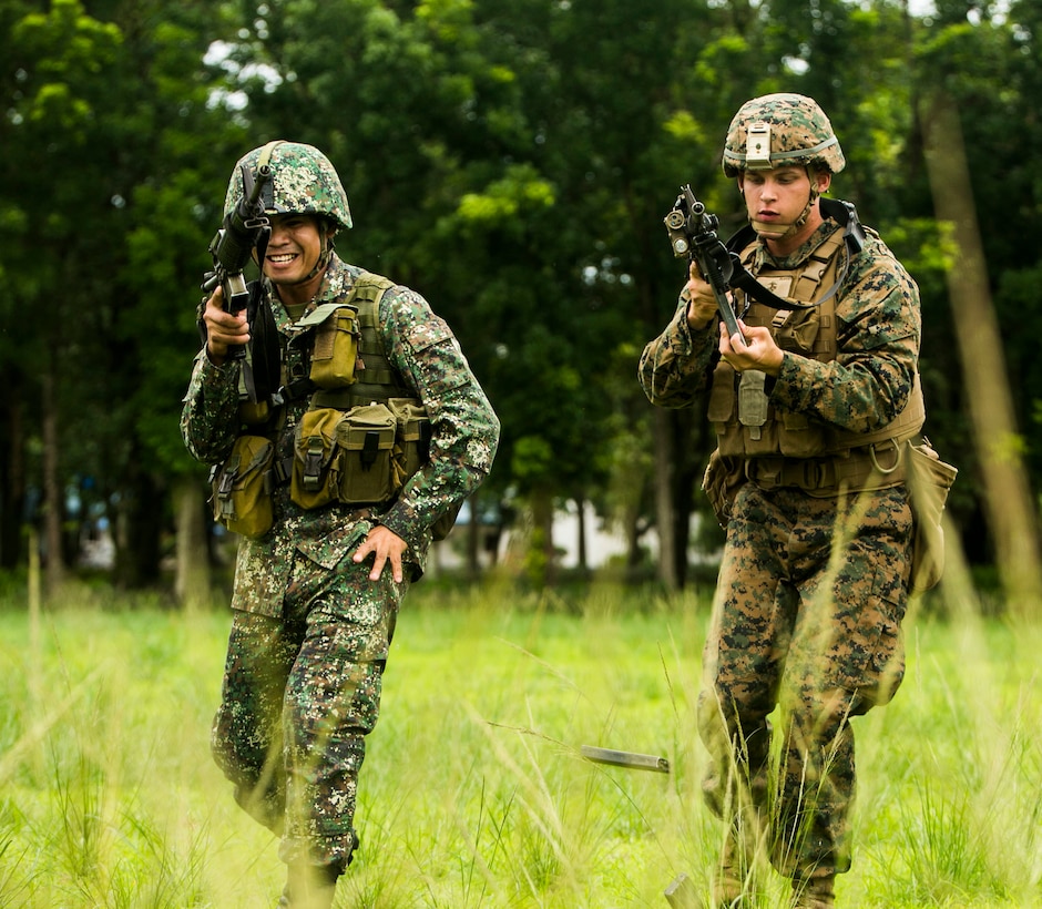 U.S. Marine Corps Lance Cpl. Brandon Burkey stands shoulder to shoulder with a Philippine Marine while instructing him on proper reloading techniques during Air Assault Support Exercise 2015-2 on Basa Air Base in Pampanga, Philippines, July 15, 2015. The Marines went through a number of different scenarios to include fire and maneuver as well as urban operations. AASE is a bilateral training event focused on strengthening the alliance between the Philippines and the U.S. Burkey is a riflemen with 1st Platoon, Fox Company, 2nd Battalion, 3rd Marine Division and is attached through the Unit Deployment Program to III Marine Expeditionary Force. The Philippine Marines are with Marine Battalion Landing Team 1, 1st Battalion, Philippine Marine Corps. 