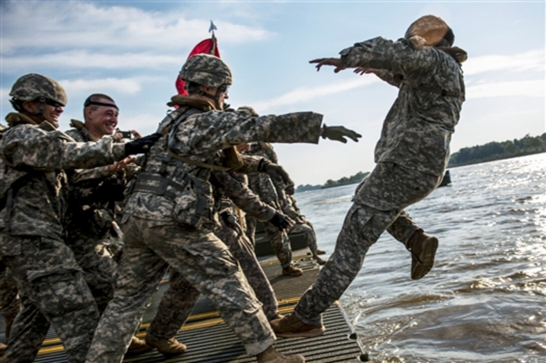 Soldiers share a light moment with Army 1st Lt. Shane Yingling as they toss the executive officer into the Arkansas River during Operation River Assault 2015 on Fort Chaffee, Ark., Aug. 4, 2015. The exercise involves Army engineers and other support elements to create a modular floating bridge. The soldiers are assigned to the Army Reserve's 310th Engineer Company.