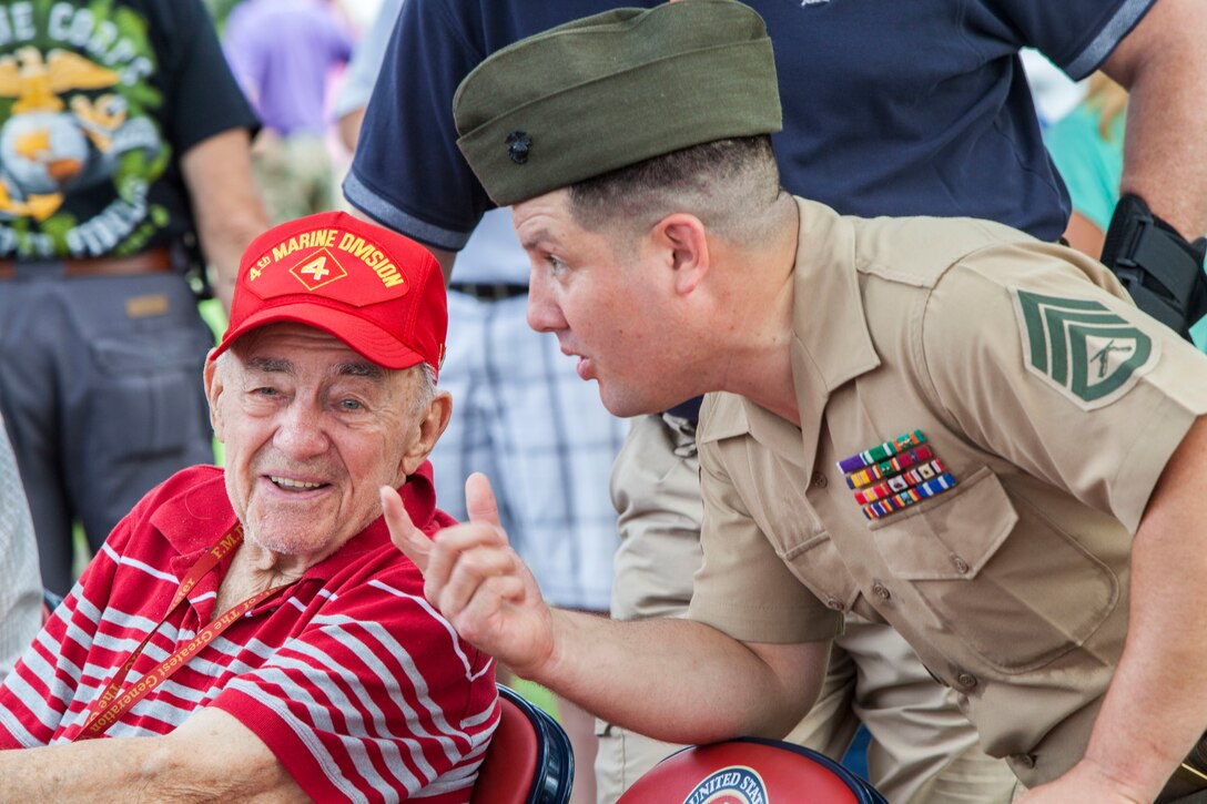 A veteran of 4th Marine Division speaks with Marine Corps Staff Sgt. Albert Carls after a morning colors ceremony on Camp Lejeune, N.C., Aug. 4, 2015. 