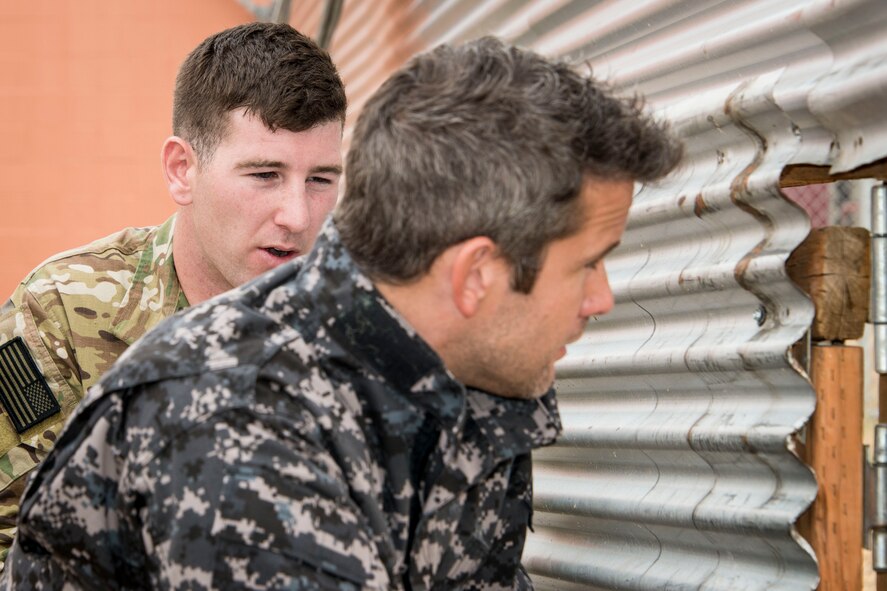 Senior Airman Alan Hamilton, 22nd Training Squadron Survival, Evasion, Resistance and Escape specialist, explains evasion tactics to U.S. Representative and Illinois Air National Guard Maj. Adam Kinzinger during the representative’s visit Aug. 3, 2015, at Fairchild Air Force Base, Wash. Kinzinger came to get a first-hand perspective on SERE training and how it prepares America’s service members for deployments overseas as part of a joint and coalition task force. (U.S. Air Force photo/Staff Sgt. Benjamin W. Stratton)