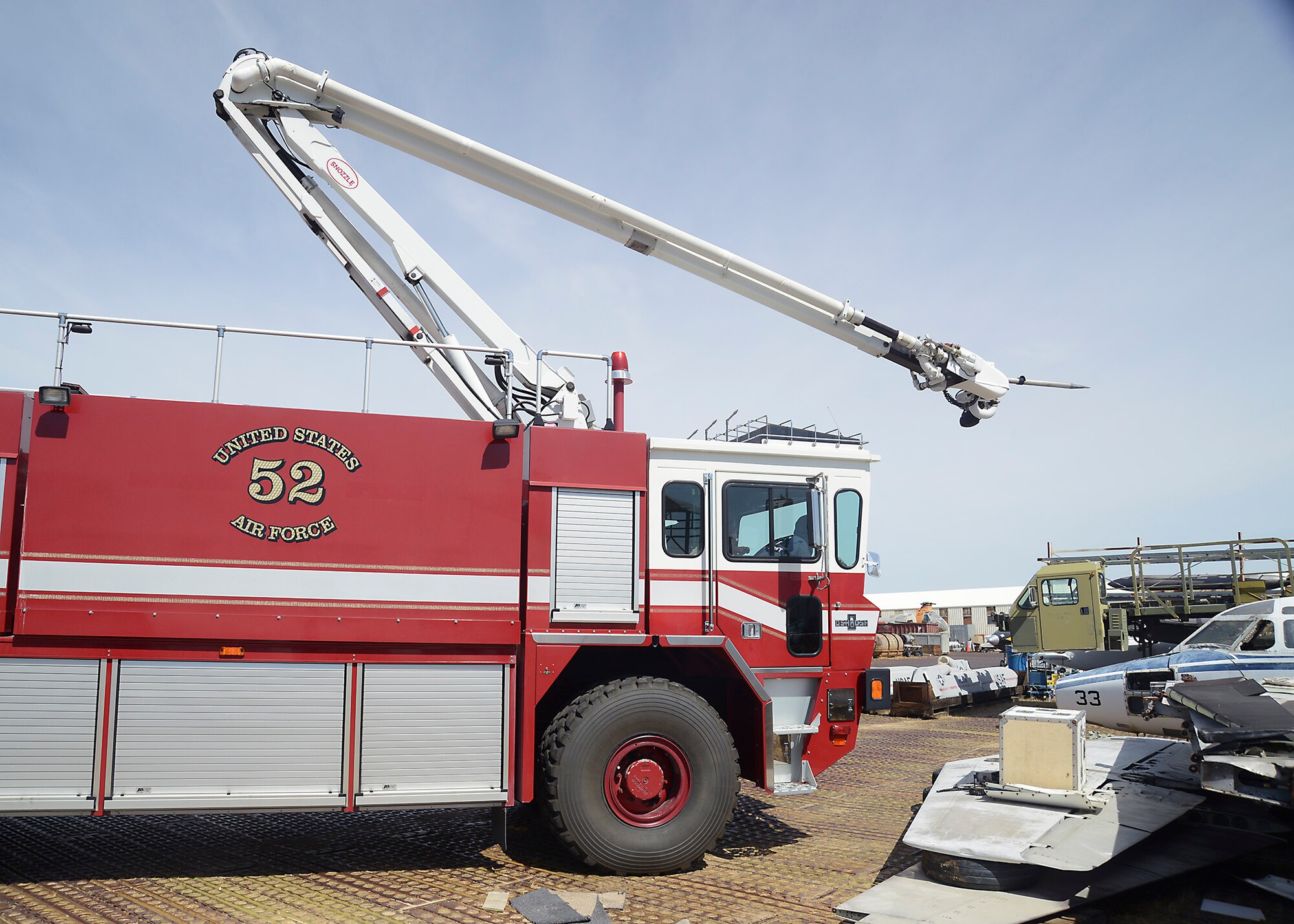 A fire engine moves into place to use the penetrating boom attached to an extending arm, reaching out to the T-39. (U.S. Air Force photo by Patric Lovato)