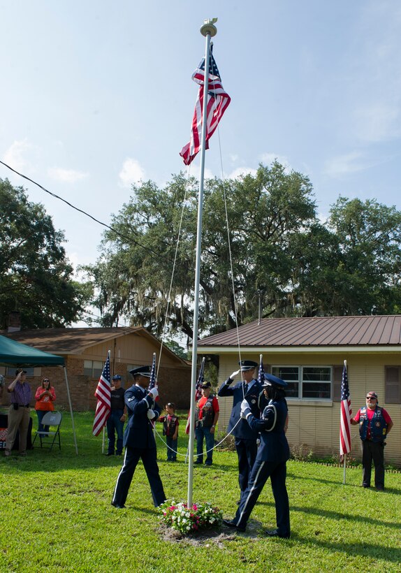 Tyndall Honor Guard members raise the U.S. flag on Jules Olivier, Army Air Corps and Air Force veteran, new flag pole July 31 at his house.  Panama City’s Home Depot installed a flag pole for Olivier free of charge, and members of Team Tyndall presented him with an American flag that had been flown over Tyndall. (U.S. Air Force photo by Senior Airman Alex Echols/Released)