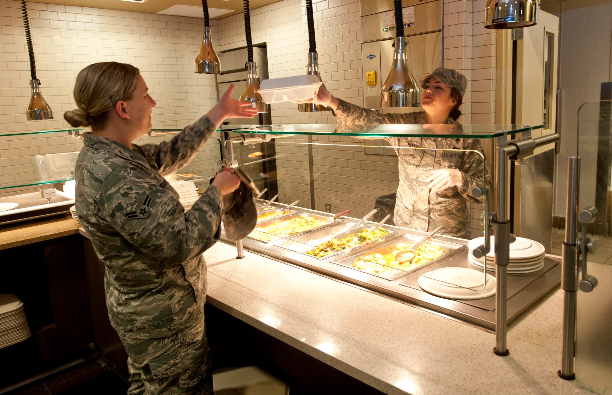 Airman 1st Class Jessica Paynt, a 92nd Force Support Squadron services specialist, gives an Airman her meal Aug. 3, 2015, in the Warrior Dinning Facility at Fairchild Air Force Base, Wash. Since re-opening, the dining facility Airmen have been able to use and improve their skills in all the different areas of the dining facility, something they were not able to do before the renovations. (U.S. Air Force photo by/Airman Sean Campbell)