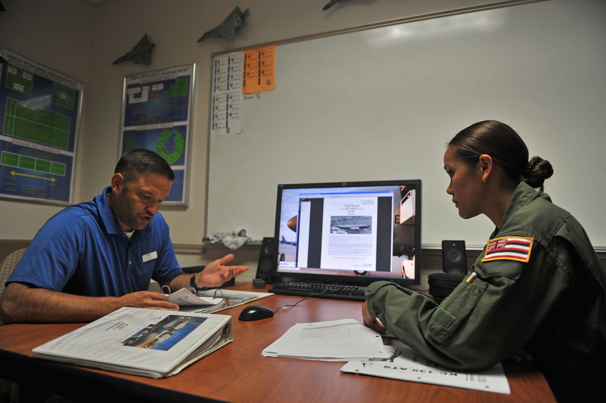 ALTUS AIR FORCE BASE, Okla. – Brian Buss, 97th Training Squadron boom operator instructor, and U.S. Air Force Senior Airman Mary Claire Bolo, 203rd Air Refueling Squadron boom operator student, Hawaii Air National Guard, conduct a pre-briefing before stepping inside a U.S. Air Force KC-135 Stratotanker refueling aircraft Boom Operator Weapons System Trainer, July 30, 2015. The briefing prepares students for what they may encounter during the training simulation and allows them to ask any last minute questions before being evaluated. (U.S. Air Force photo by Senior Airman Dillon Davis/Released)