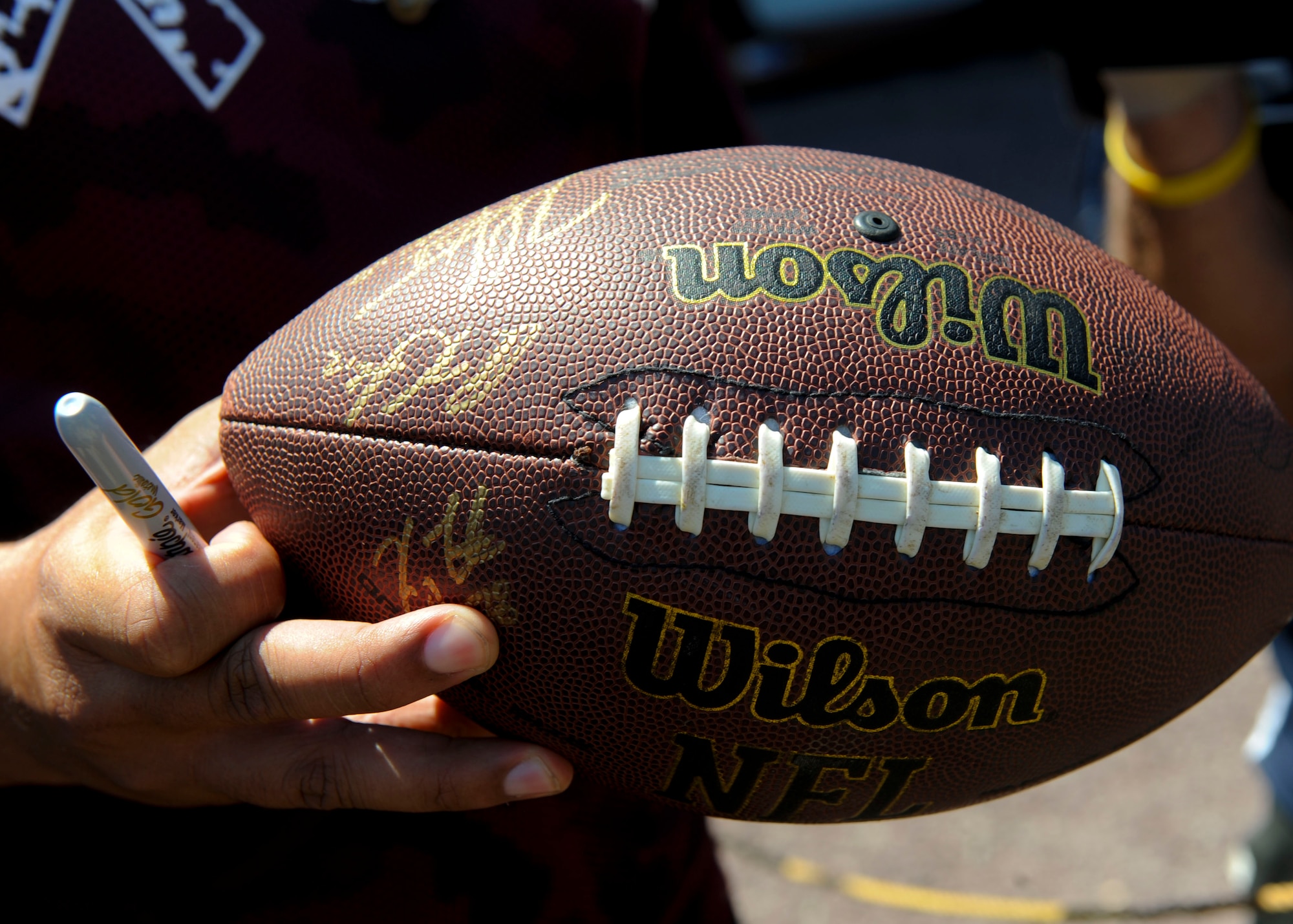 A U.S. Service member displays his autographed football at the Washington Redskins training camp at the Bon Secours Training Center in Richmond, Va., July 31, 2015. The Service members watched the practice from the field sidelines, and met with team players.  (U.S. Air Force photo by Staff Sgt. John D. Strong II/Released)
