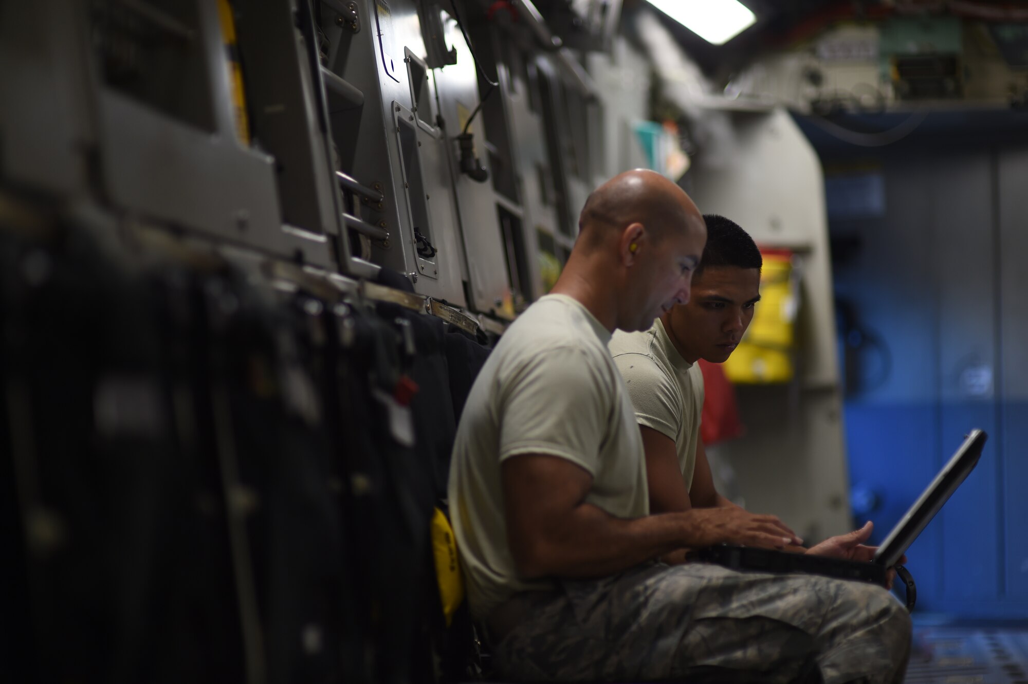 Tech. Sgt. Kevin Flores and Airmen First Class Aaron Daite from the 154th Maintenances Squadron look at a digital technical order after troubleshooting a maintenance issue on a C-17 Globemaster III during the 535th Airlift Squadron’s Warrior Day on Joint Base Pearl Harbor-Hickam, Hawaii July 31, 2015. The 15th and 154th aircraft maintenance squadrons generated the five C-17 aircraft and the four F-22 used during the Warrior Day training. (U.S. Air Force photo by Tech. Sgt. Aaron Oelrich/Released)

