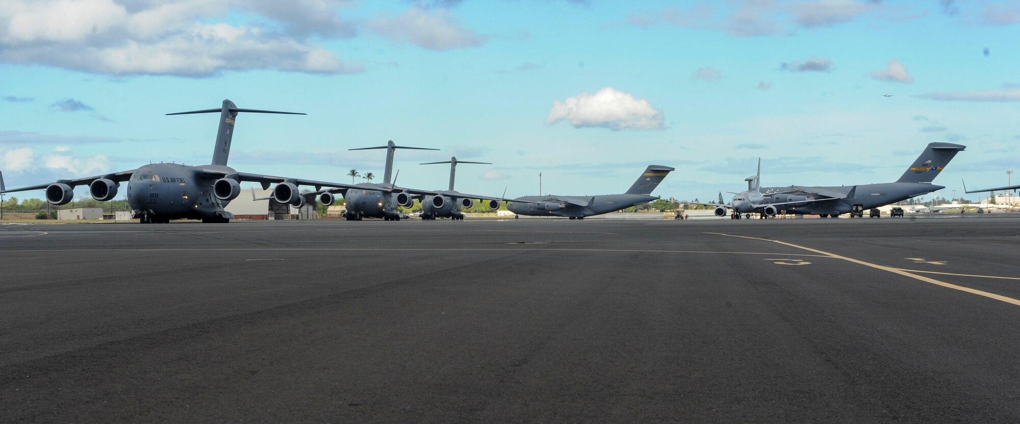 Five C-17 Globemasters III from the 535th Airlift Squadron taxi prior to take off on Joint Base Pearl Harbor-Hickam, Hawaii, July 31, 2015. The day featured the participation of 15th Wing C-17 Globemasters III and F-22 Raptors of the 199th fight squadron, as well as KC-10 Extenders from Travis Air Force Base, and tested the ability for the aircrafts and personnel to work together to complete a mission. (U.S. Air Force photo by Tech. Sgt. Terri Paden/Released)

