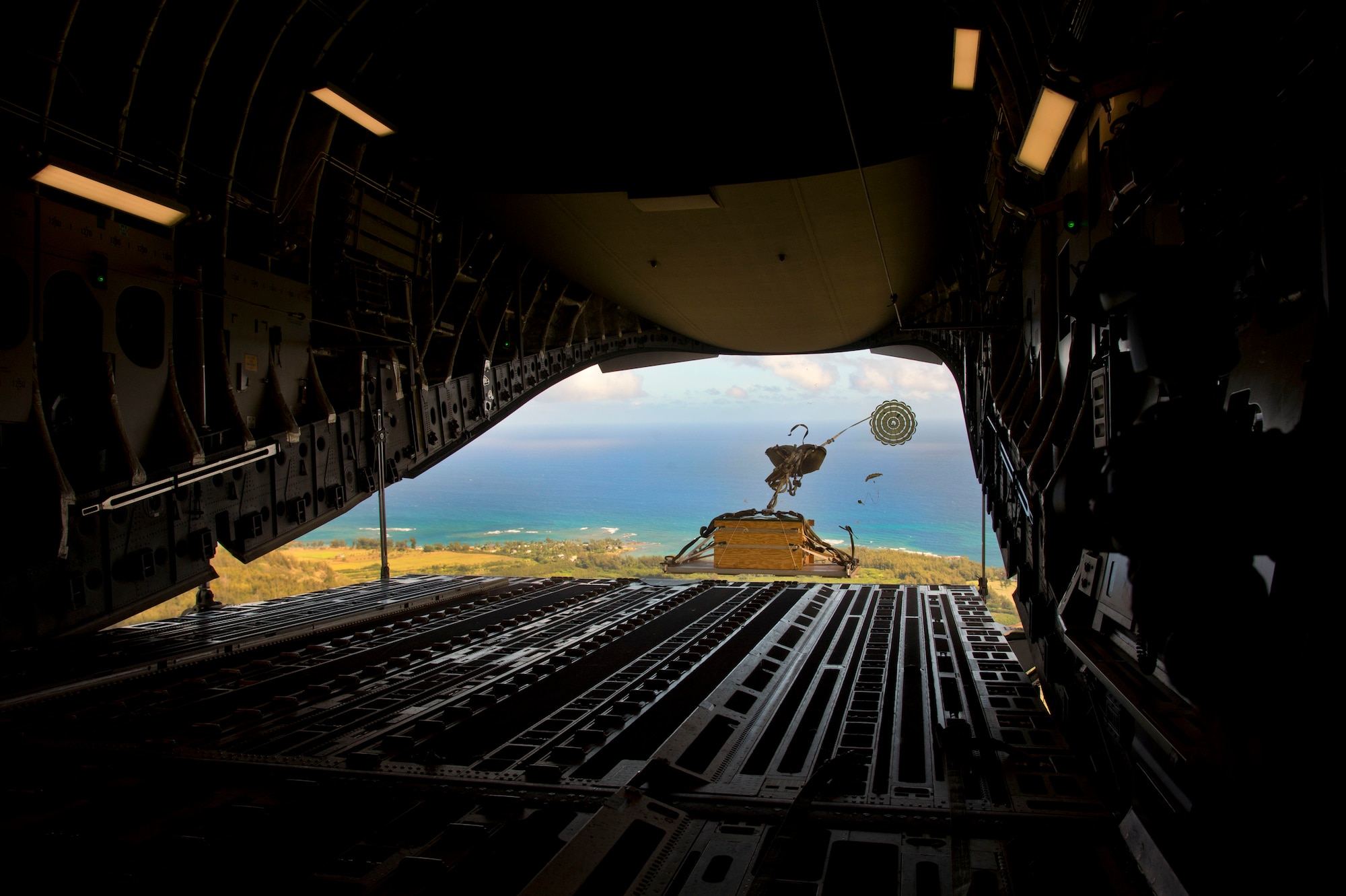 A training combat delivery system is dropped out of a C-17 Globemaster III over Kahuku Training Area as part of Warrior Day, a day dedicated to demonstrate the cooperation and capabilities of total force integration at Joint Base Pearl Harbor-Hickam, Hawaii, July 31, 2015. Training simulations also included combat maneuvers in a hostile environment and refueling operations. (U.S. Air Force photo by 2nd Lt. Kaitlin Daddona/Released)

