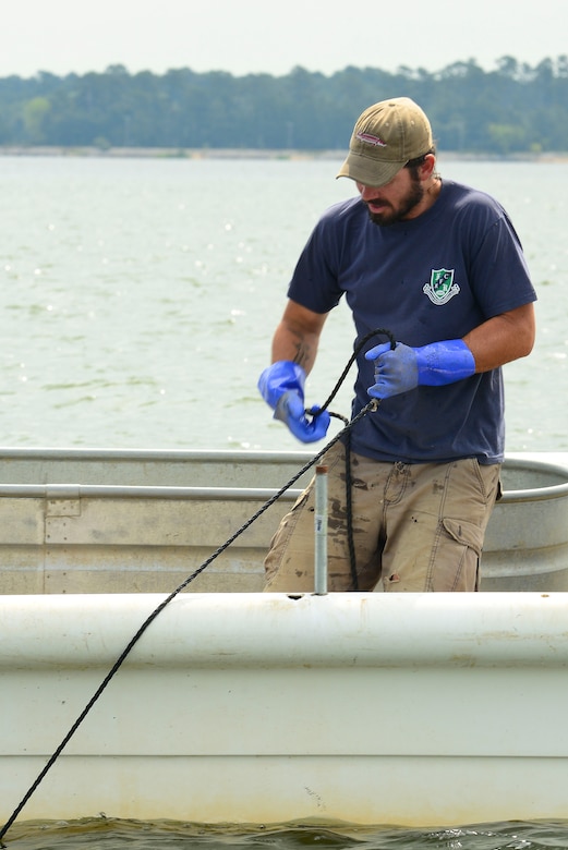 Matt Balazik, Virginia Commonwealth University Rice River Center researcher, reels in a gill net at Fort Eustis, Va., July 28, 2015. After letting the netting sit for an amount of time, Balazik and his team pulled it in, in hopes to find a sturgeon so they can tag, measure and send it back into the water to be observed for the next 10 years. (U.S. Air Force photo by Senior Airman Kimberly Nagle/Released)  